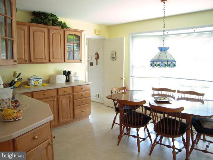 2715 Woodedge Road Silver Spring, MD 20906 - Photo 5 of 22 a kitchen with a dining table chairs and white cabinets