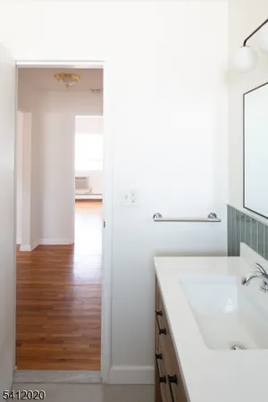 a spacious bathroom with a tub sink and mirror
