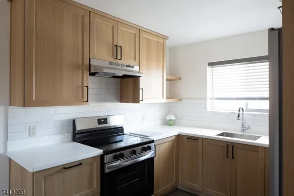 a kitchen with stainless steel appliances a sink dishwasher stove and refrigerator