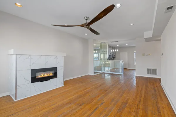 a living room with stainless steel appliances wooden floor and a fireplace