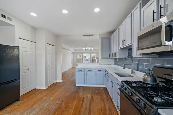 a large kitchen with stainless steel appliances granite countertop a stove and a refrigerator
