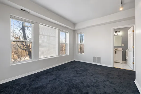 an empty room with windows and closet