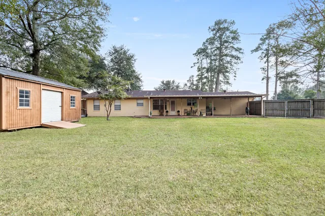 a front view of house with yard and trees in the background