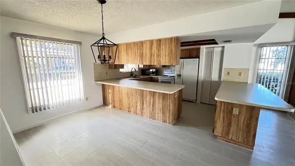 a kitchen with a white refrigerator a sink dishwasher and wooden cabinets