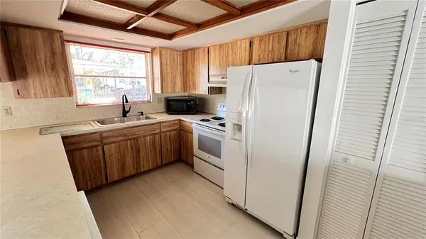 a kitchen with a sink a window and cabinets