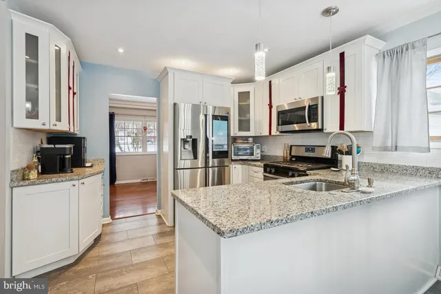 a kitchen with stainless steel appliances granite countertop a refrigerator a stove top oven a sink and dishwasher