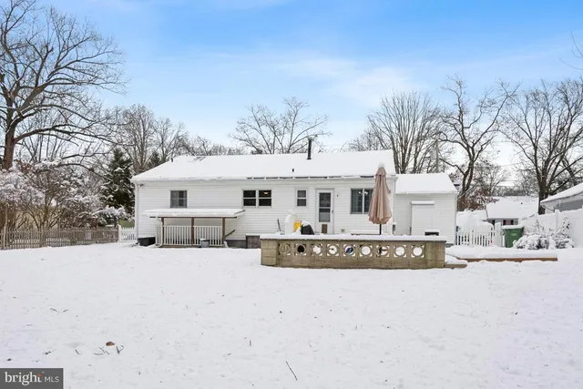 a view of a white house with a yard covered with snow in front of house