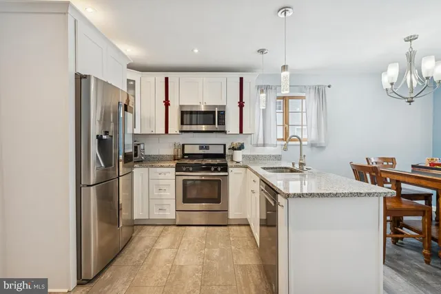 a kitchen with stainless steel appliances granite countertop a stove a sink and a refrigerator