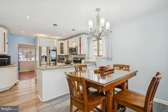 a dining room with furniture a chandelier and wooden floor