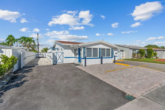 a living room with furniture a dining table and a refrigerator with wooden floor