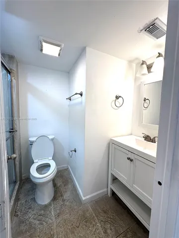 a bathroom with a sink a toilet a mirror and a shower