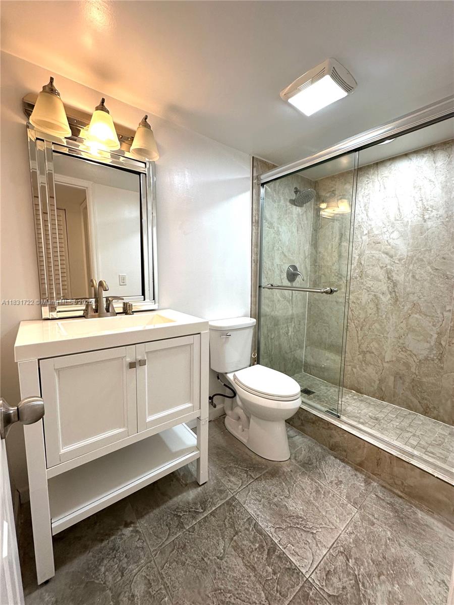 603 South State Road 7, Unit 1D Margate, FL 33068 - Photo 10 of 12 a bathroom with a toilet a sink and mirror