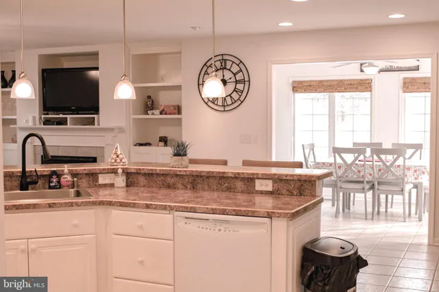 a kitchen with stainless steel appliances granite countertop a sink a stove and a wooden floors