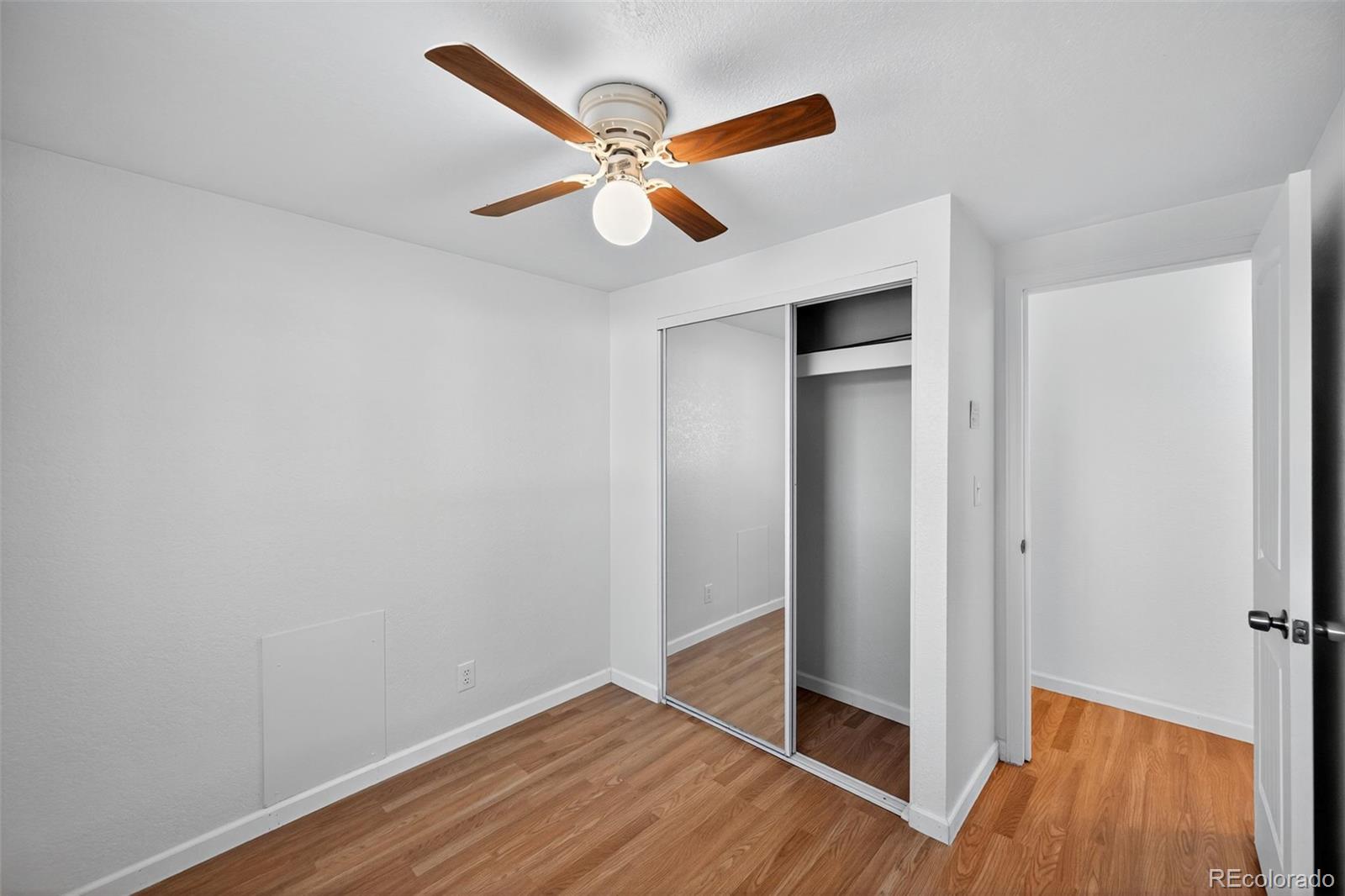 2000 Moselle Street Denver, CO 80260 - Photo 11 of 33 a view of an empty room with wooden floor and a ceiling fan