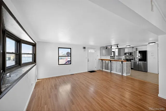 a view of a livingroom with wooden floor and a ceiling fan