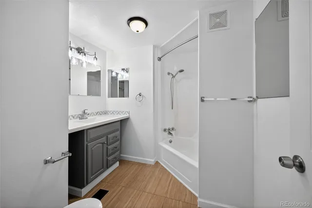 a bathroom with a granite countertop toilet a sink and a mirror