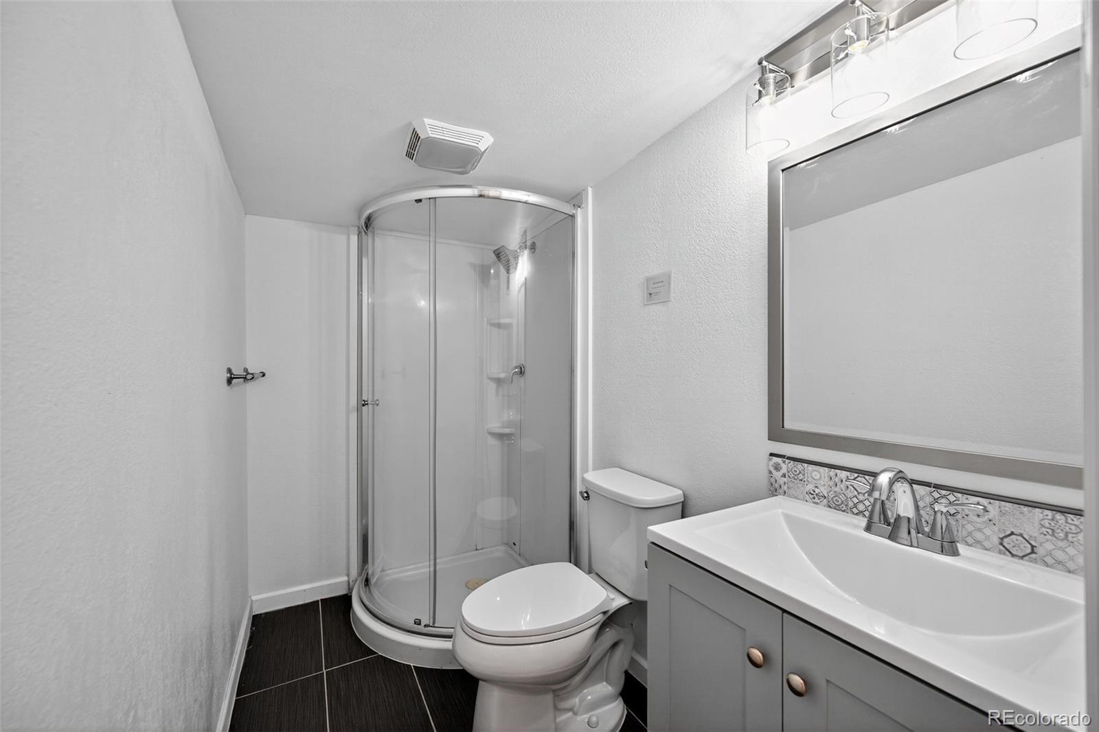 2000 Moselle Street Denver, CO 80260 - Photo 9 of 33 a bathroom with a granite countertop toilet a sink and a mirror
