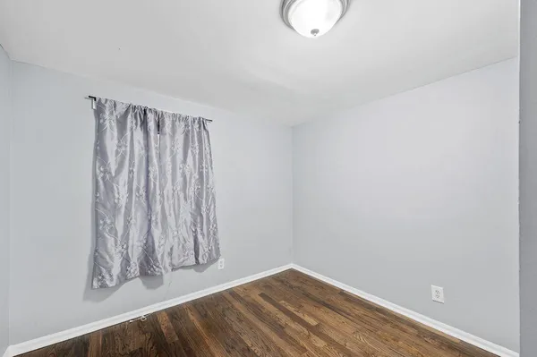 a view of a room with wooden floor and a window