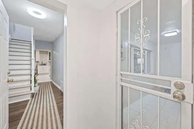 a view of a hallway with wooden floor and entryway