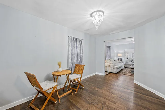 a living room with a table chairs and a chandelier