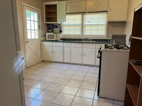a kitchen with a stove a sink and a window