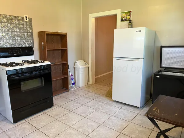 a white refrigerator freezer and a stove sitting inside of a kitchen
