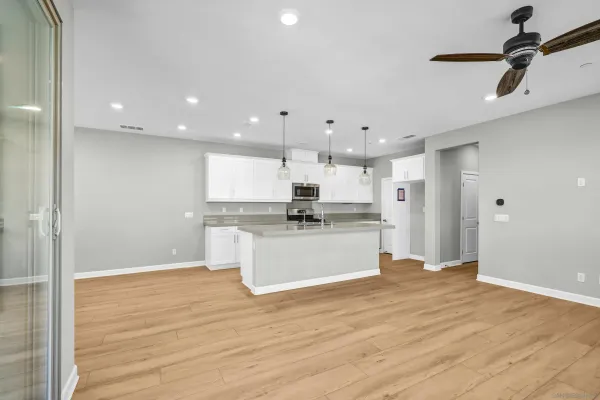 a kitchen with kitchen island white cabinets and stainless steel appliances