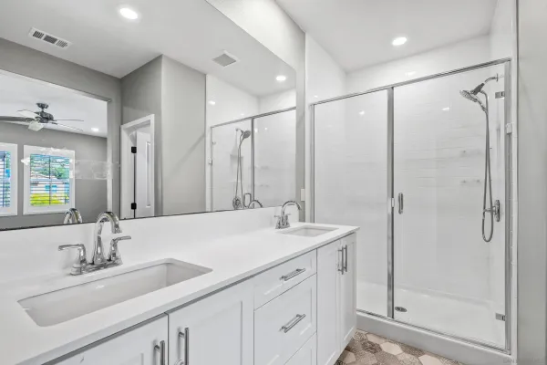 a bathroom with a double vanity sink mirror double and shower