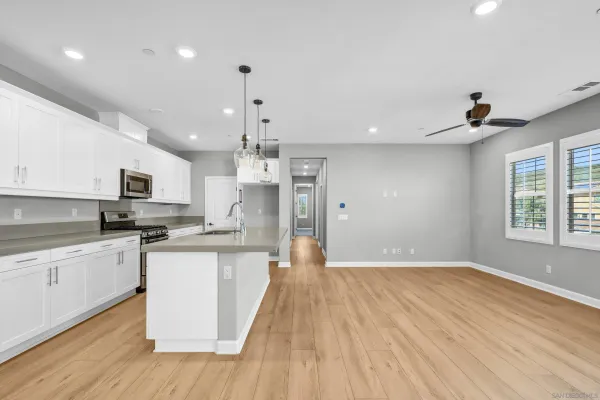 a view of a kitchen with stainless steel appliances granite countertop a sink and wooden floor