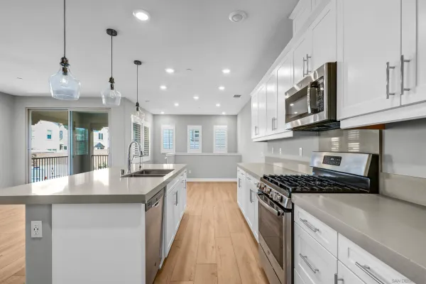 a kitchen with stainless steel appliances granite countertop a lot of counter space and wooden floors