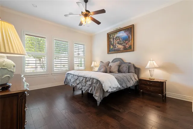 a bedroom with a bed painting on wall and a large window