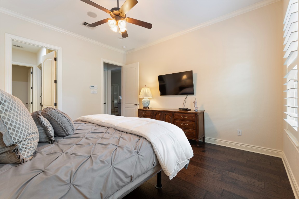 108-2 Rivalto Circle, Unit 5 Lakeway, TX 78734 - Photo 16 of 35 Bedroom with dark wood-style flooring, crown molding, and ceiling fan