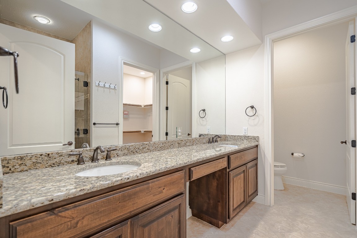 108-2 Rivalto Circle, Unit 5 Lakeway, TX 78734 - Photo 17 of 35 Full bath with a stall shower, double vanity, a walk in closet, recessed lighting, and light tile patterned floors