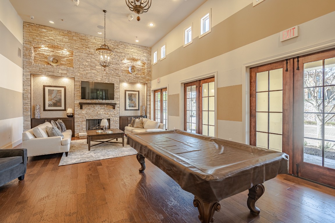 108-2 Rivalto Circle, Unit 5 Lakeway, TX 78734 - Photo 33 of 35 Game room with a stone fireplace, recessed lighting, healthy amount of natural light, french doors, and a towering ceiling