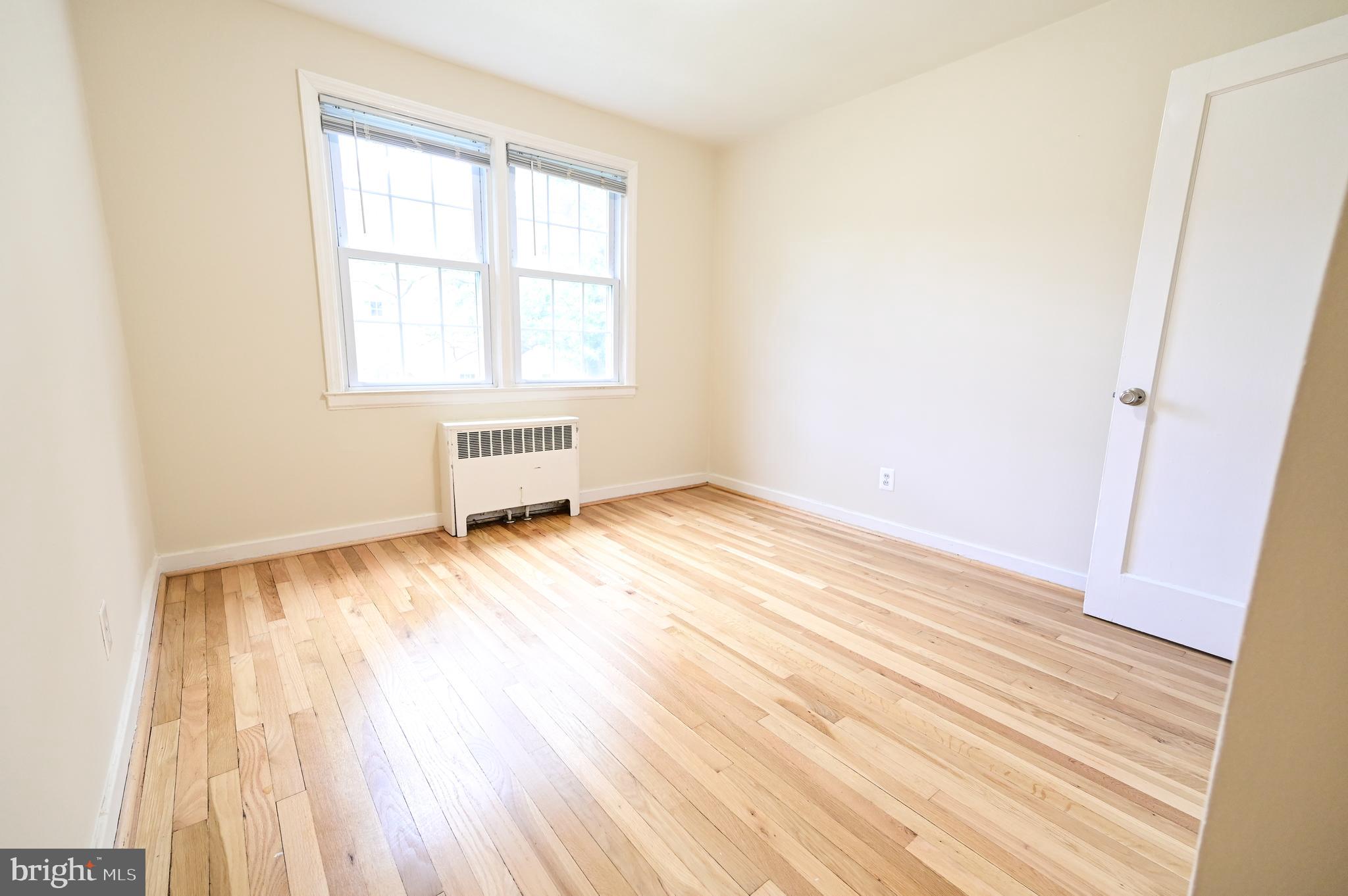 8331 Grubb Road, Unit G201 Silver Spring, MD 20910 - Photo 4 of 15 an empty room with wooden floor and windows