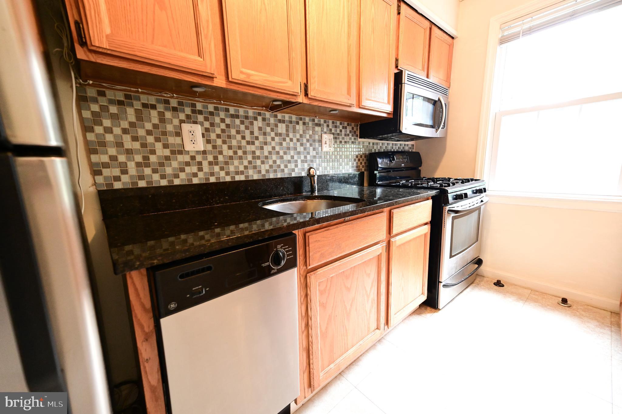 8331 Grubb Road, Unit G201 Silver Spring, MD 20910 - Photo 6 of 15 a kitchen with stainless steel appliances a stove and a refrigerator