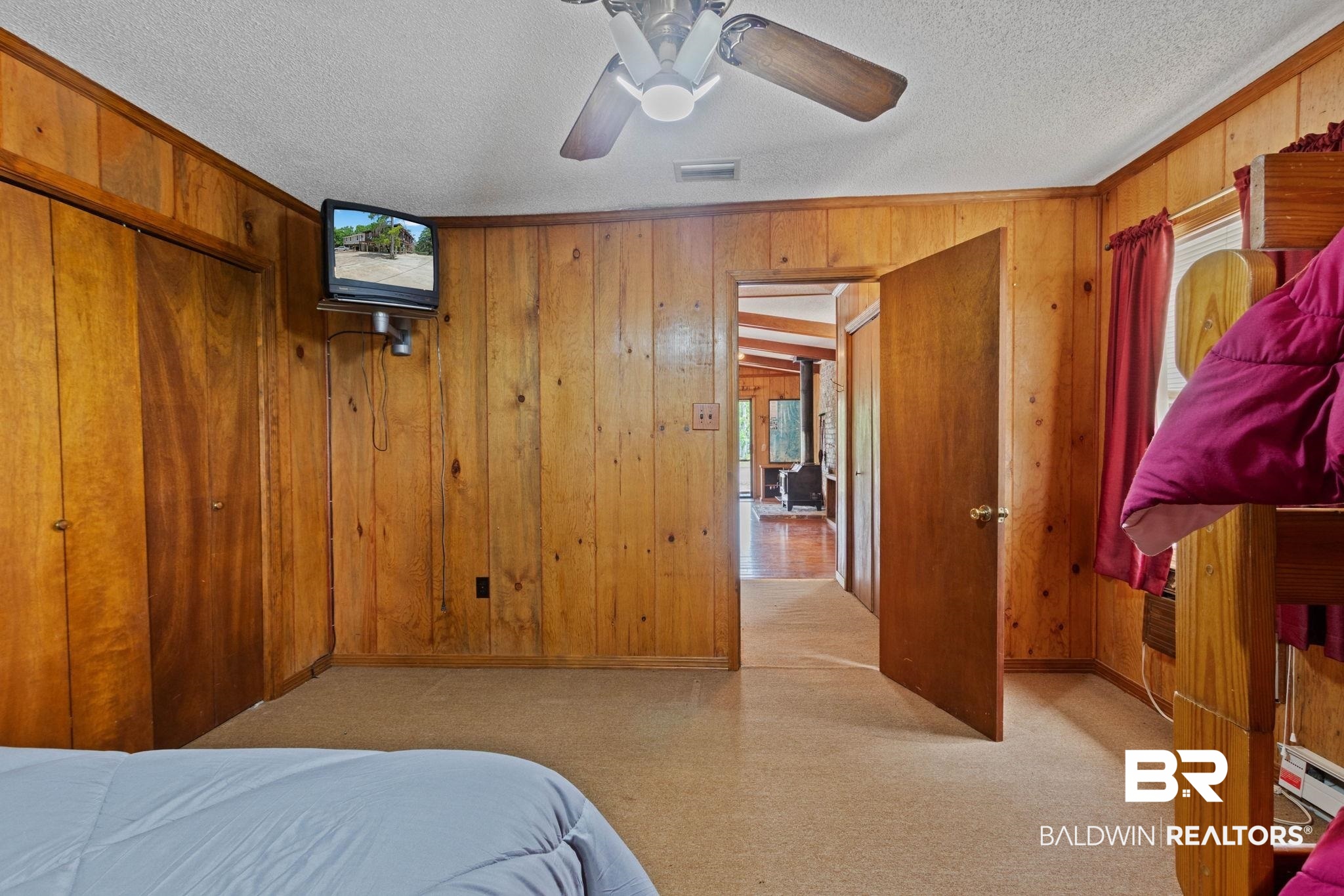 8153 Bryant's Lndg Road Stockton, AL 36579 - Photo 45 of 87 Room featuring wood paneling, a ceiling fan with integrated lighting, and neutral tone carpeting