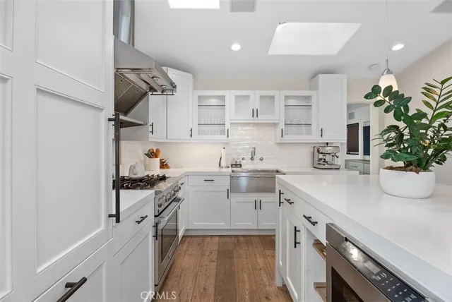 a kitchen with white cabinets and appliances