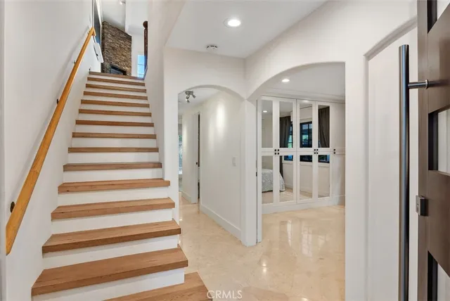 a view of a hallway to a bedroom with wooden floor and entryway