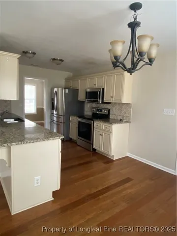 a kitchen with stainless steel appliances granite countertop a sink a stove top oven a counter space and cabinets