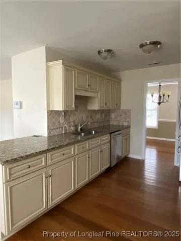a kitchen with granite countertop white cabinets and white appliances