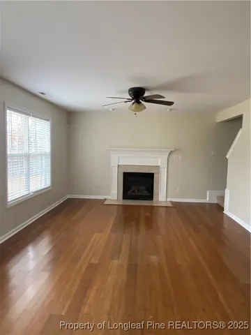 an empty room with windows and fireplace