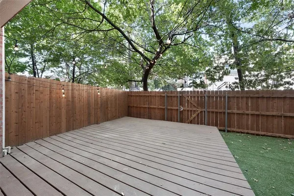 a view of a backyard with a tree and wooden fence