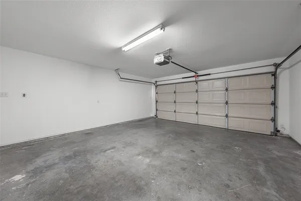 a view of a backyard with large trees and wooden fence