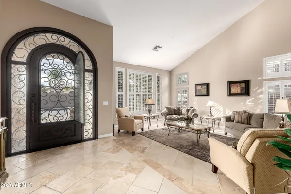 a spacious bedroom with a bed and a chandelier