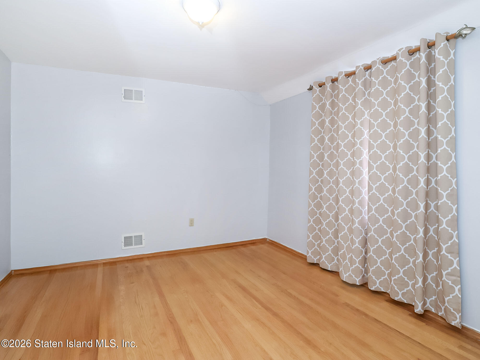 45 Fairlawn Loop Staten Island, NY 10308 - Photo 20 of 49 a view of an empty room with wooden floor and a window