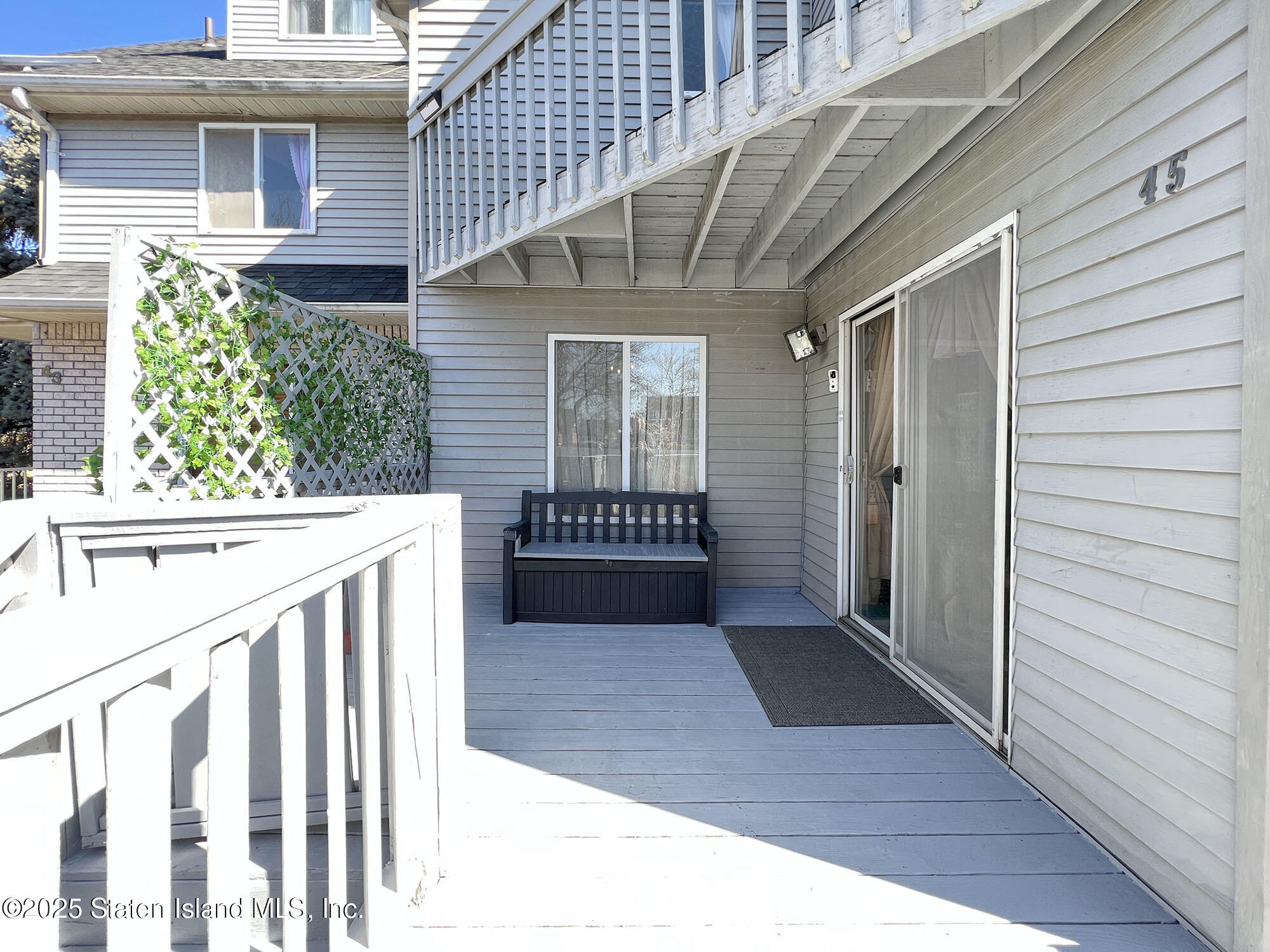 45 Fairlawn Loop Staten Island, NY 10308 - Photo 3 of 49 a view of a porch with wooden floor and a bench