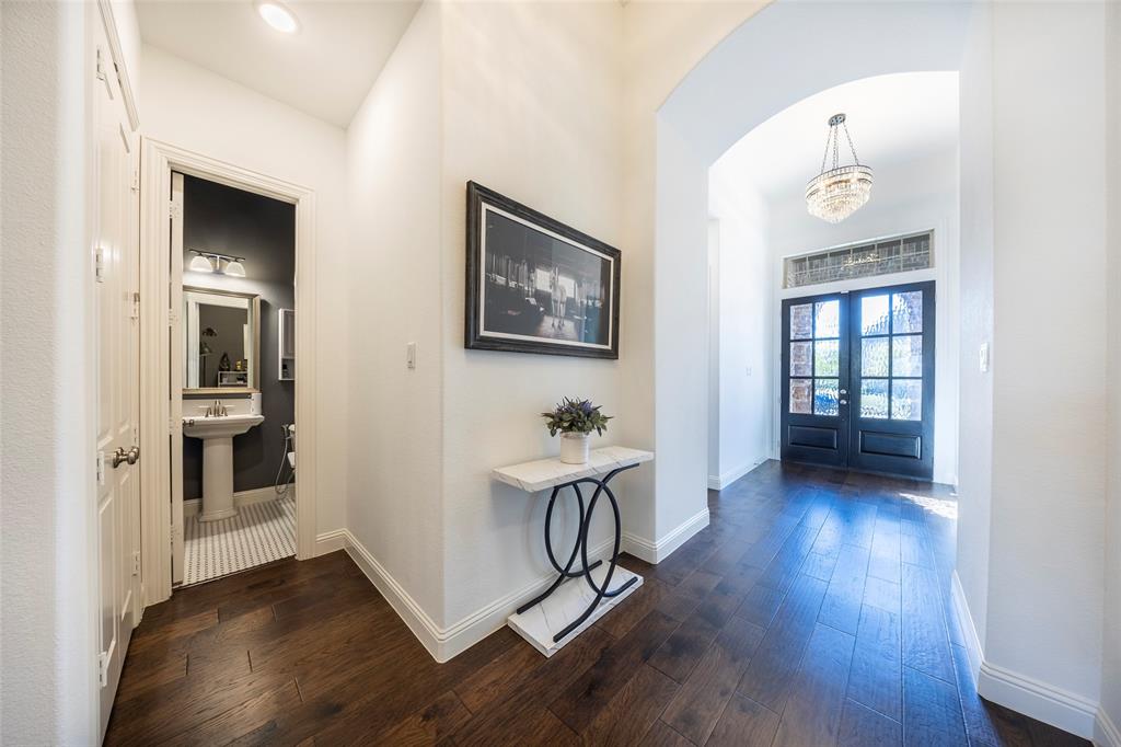 1650 Oakcrest Drive Prosper, TX 75078 - Photo 6 of 40 Hall with dark wood finished floors, french doors, and a chandelier