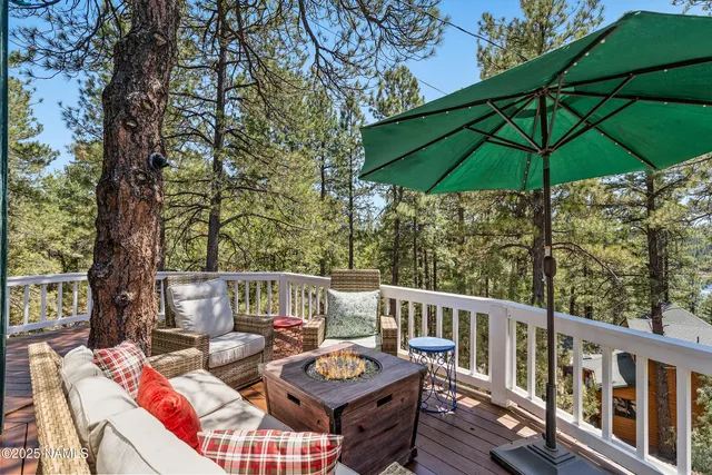 a view of deck with furniture and umbrella