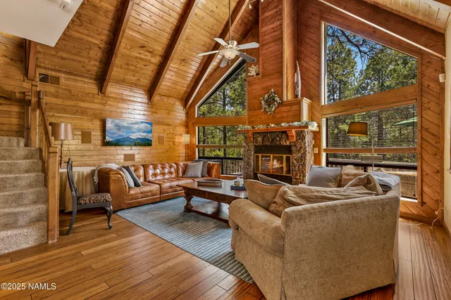 a living room with fireplace furniture and a large window